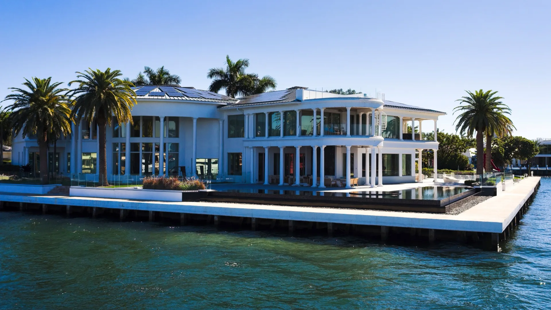 Waterfront home with palms and a private dock in Vero Beach, Florida, overlooking the water